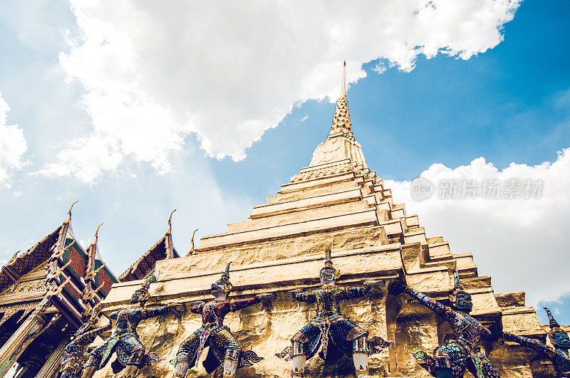 低角度观看黄金Wat塔与雕像在Wat Phra Kaew，泰国